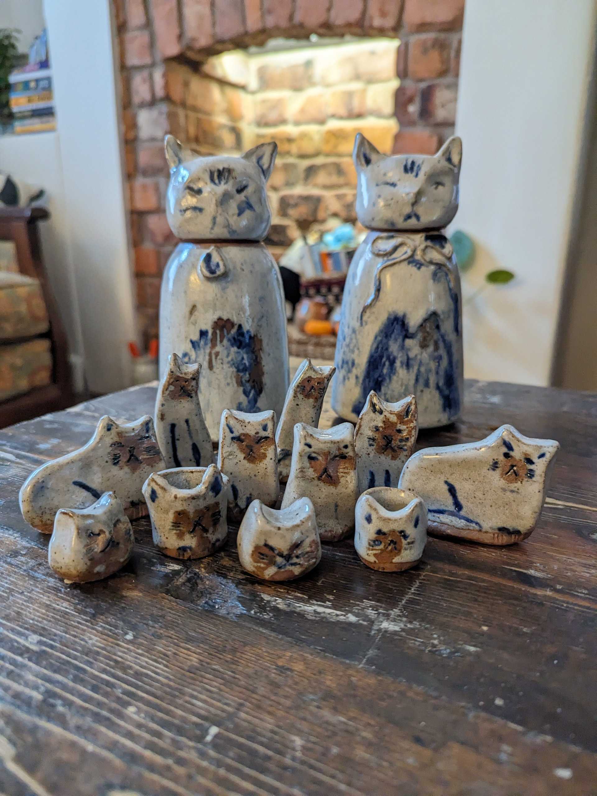 Small blue and white cat figurines arranged on a wooden table