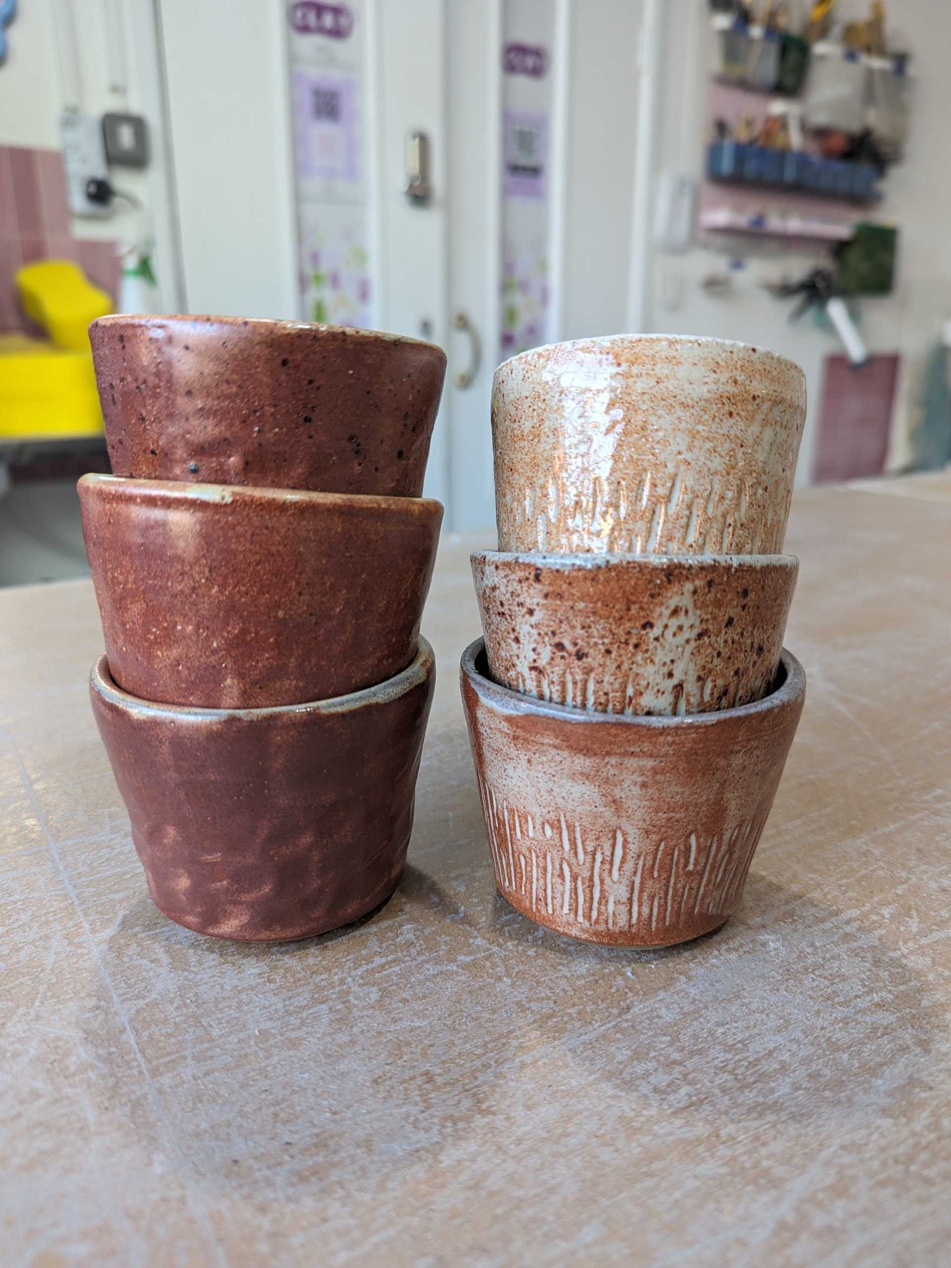 Stack of rust-coloured glaze espresso cups